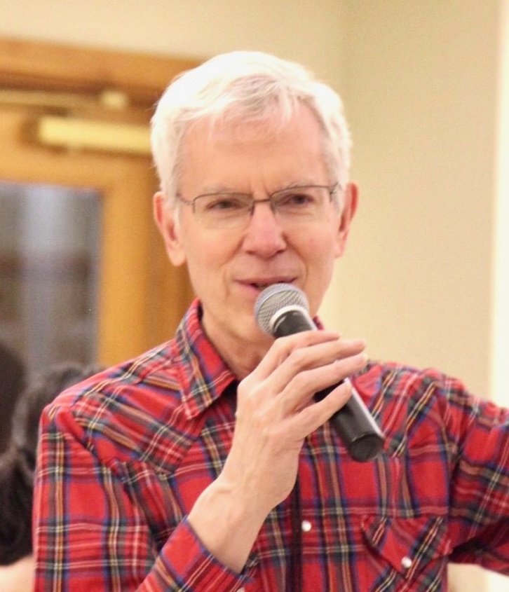 Tony Parkes calling in a red plaid shirt.